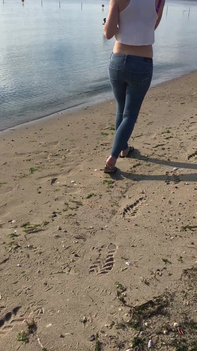 Girl peeing her jeans at beach